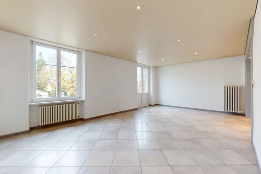 chambre vide avec lumière naturelle, carrelage, et radiateur
