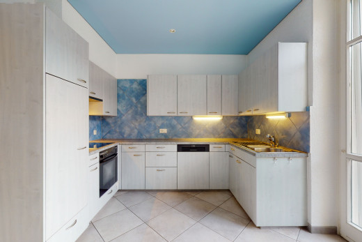 küche mit geschirrspüler, ofen, elektrischem kochfeld, dunklen arbeitsplatten, weissen schränken und hellen fliesenböden