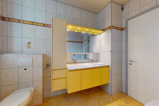 salle de bains avec carrelage, meuble-lavabo, toilettes, vasque, et miroir
