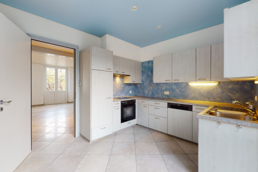 küche mit natürlichen licht, ofen, geschirrspüler, weissen schränken und hellen fliesenböden