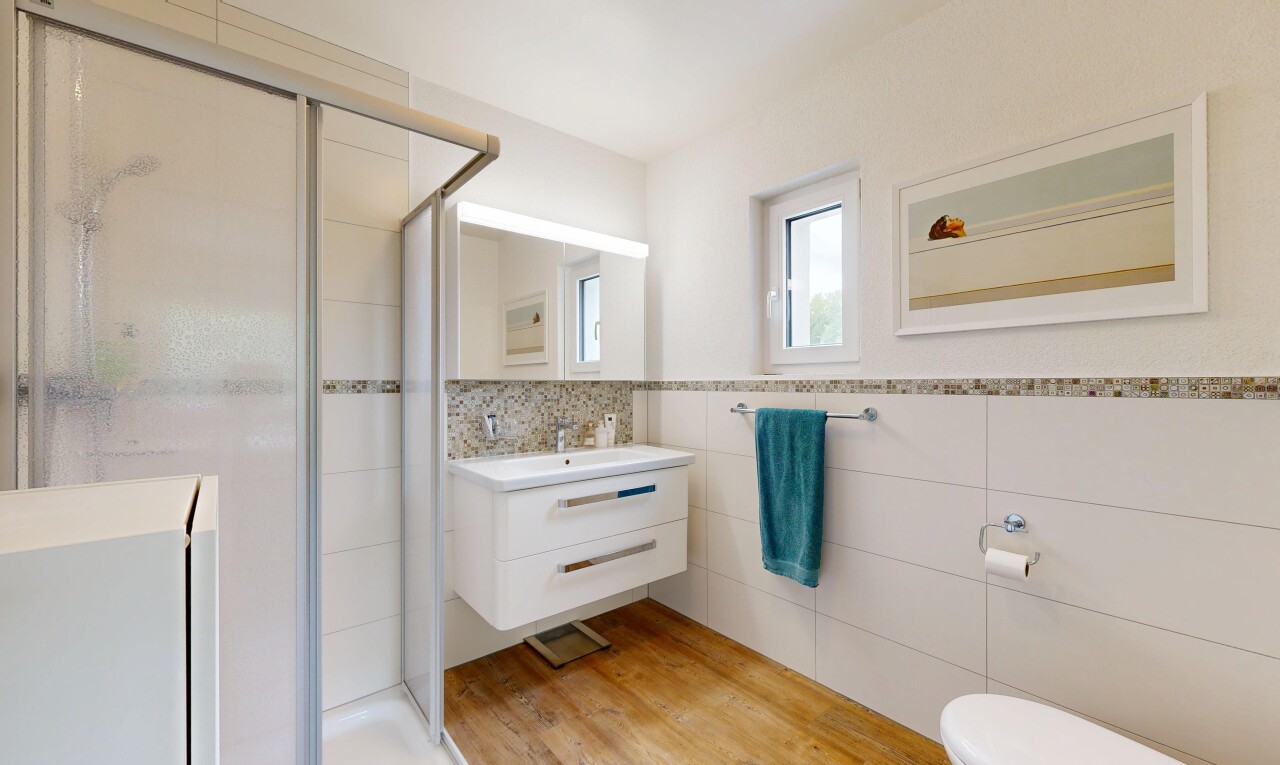 salle de bains avec douche, salle de bain complète, miroir, lavabo (ou coiffeuse selon le contexte), et mur en carrelage