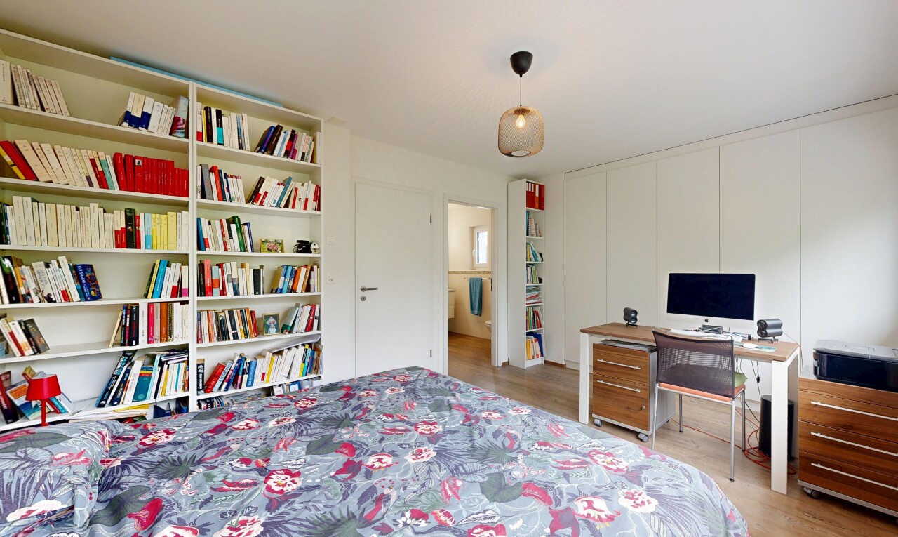 chambre avec inside property, télévision, sol en finition bois, wood finish floor, et light floor