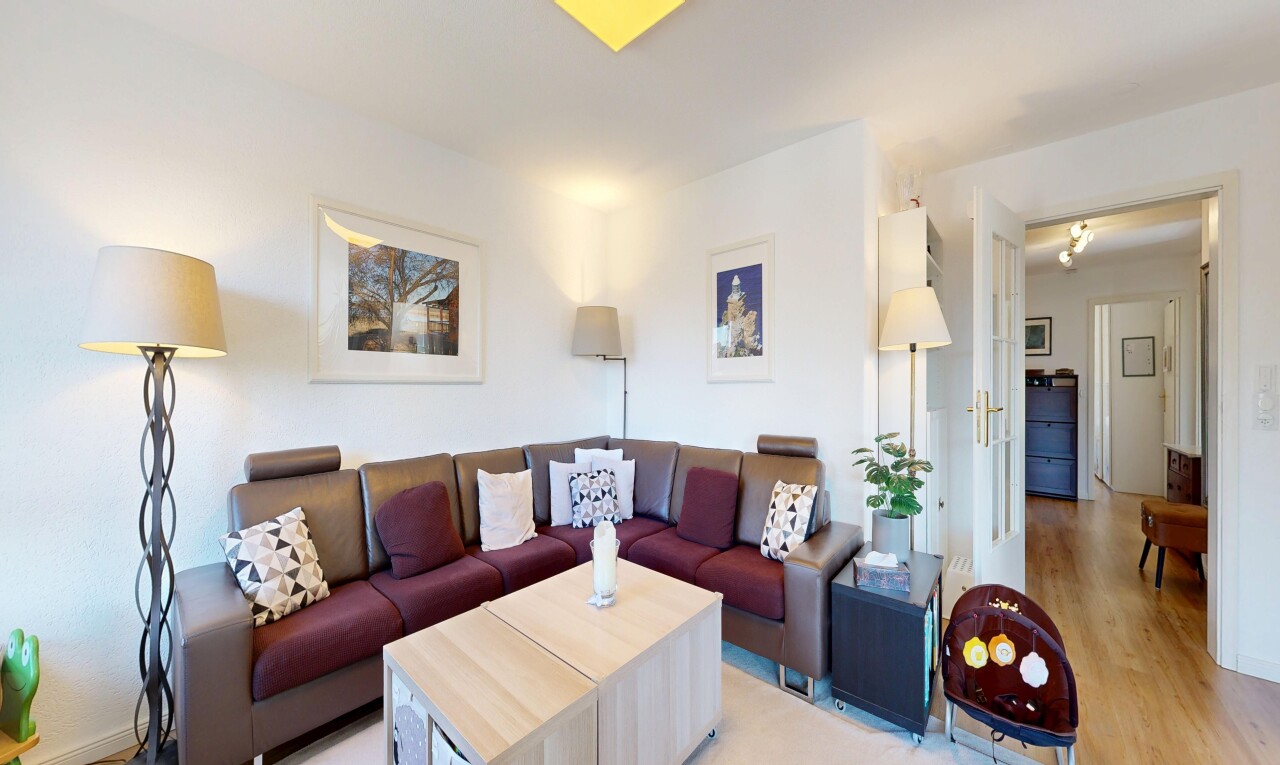 salon avec cloison sèche, drywall, inside property, sol en finition bois, et wood finish floor