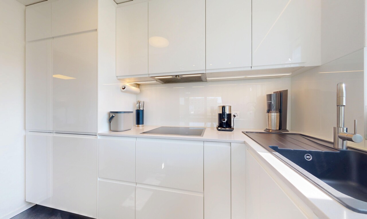 cuisine avec armoires blanches, white cabinets, évier, armoires à panneau plat, et flat panel cabinets