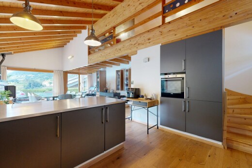 cuisine avec éclairage suspendu, lumière naturelle, natural light, sol en finition bois, et wood finish floor