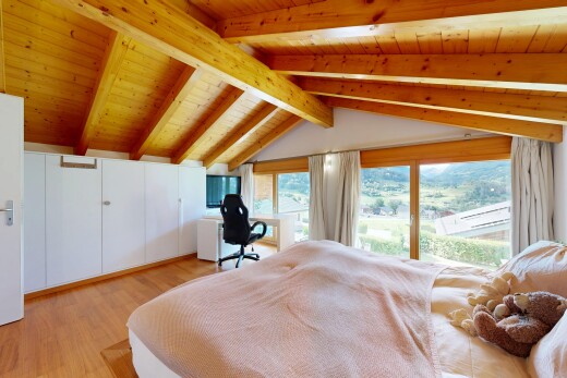chambre avec espace bureau, wood finish floor, sol en finition bois, beamed ceiling, et plafond à poutres