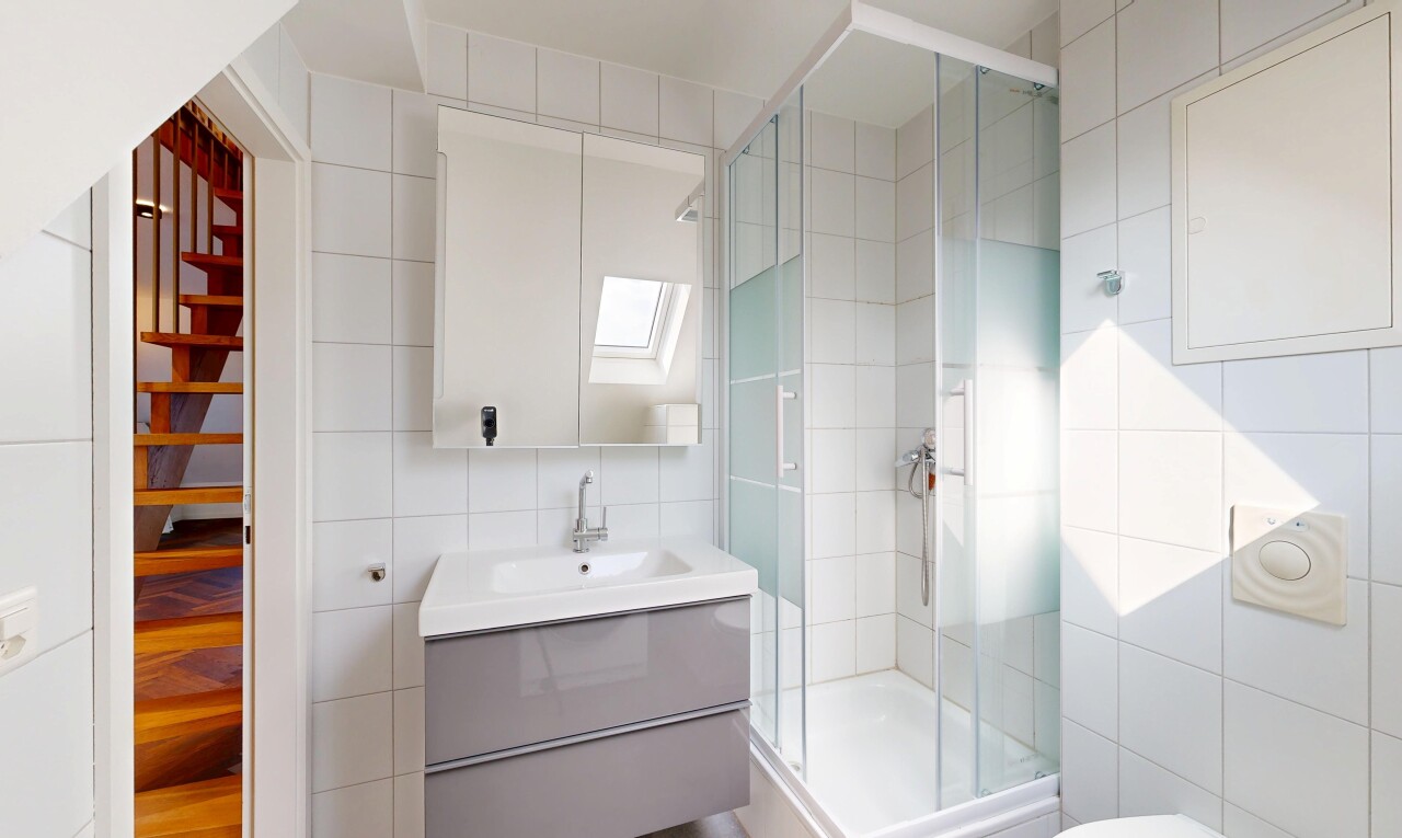 salle de bains avec mur en carrelage, tile wall, lavabo (ou coiffeuse selon le contexte), inside property, et miroir