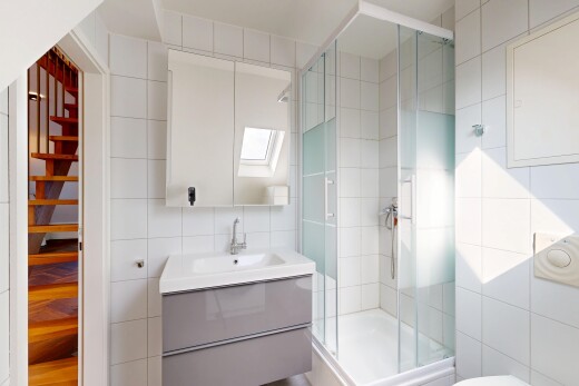 salle de bains avec mur en carrelage, tile wall, lavabo (ou coiffeuse selon le contexte), inside property, et miroir