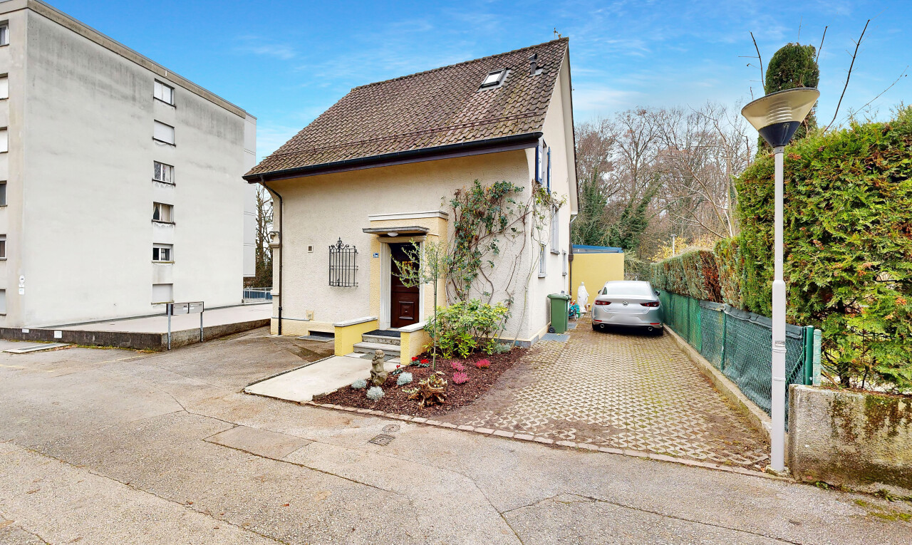 façade avec bardage en stuc, aire de stationnement, property visible, clôture, et day time