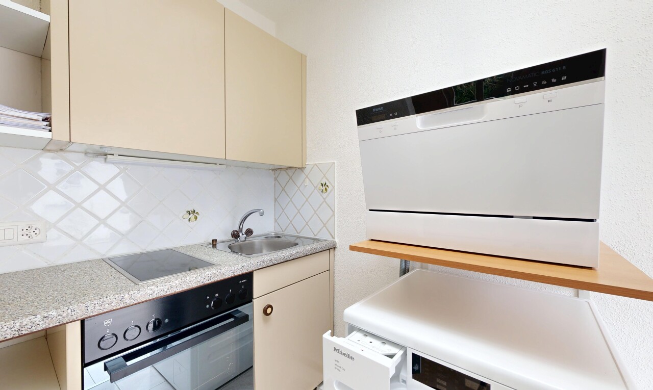 cuisine avec armoires crème, plans de travail, four, dosseret, et backsplash