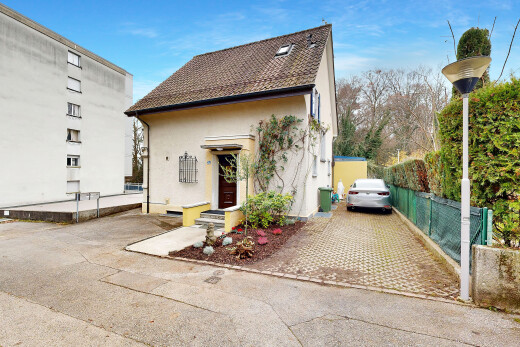 façade avec bardage en stuc, aire de stationnement, property visible, clôture, et day time