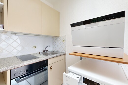 cuisine avec armoires crème, plans de travail, four, dosseret, et backsplash