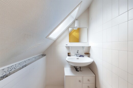 salle de bains avec puits de lumière, mur en carrelage, tile wall, miroir, et lavabo (ou coiffeuse selon le contexte)