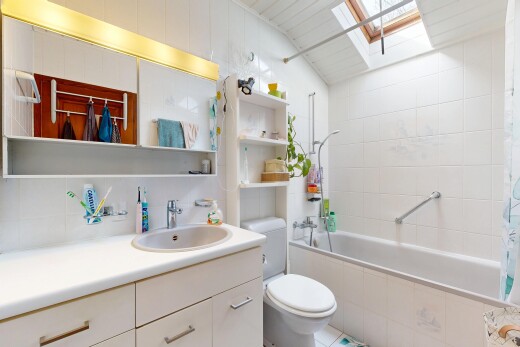 salle de bains avec puits de lumière, lavabo (ou coiffeuse selon le contexte), miroir, toilette, et inside property
