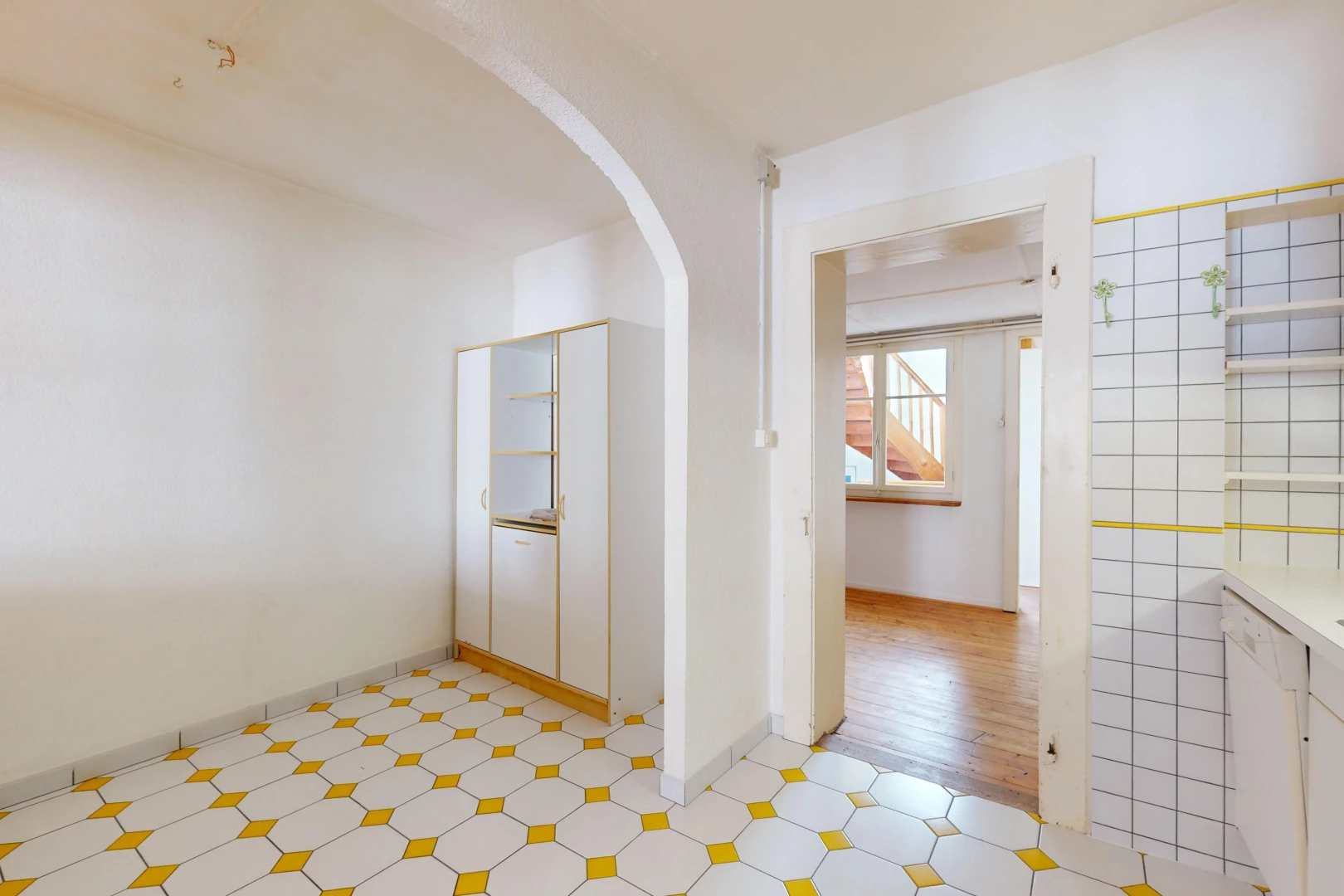 couloir avec plancher de bois, carrelage, lumière naturelle, passerelles voûtées, et mur carrelé