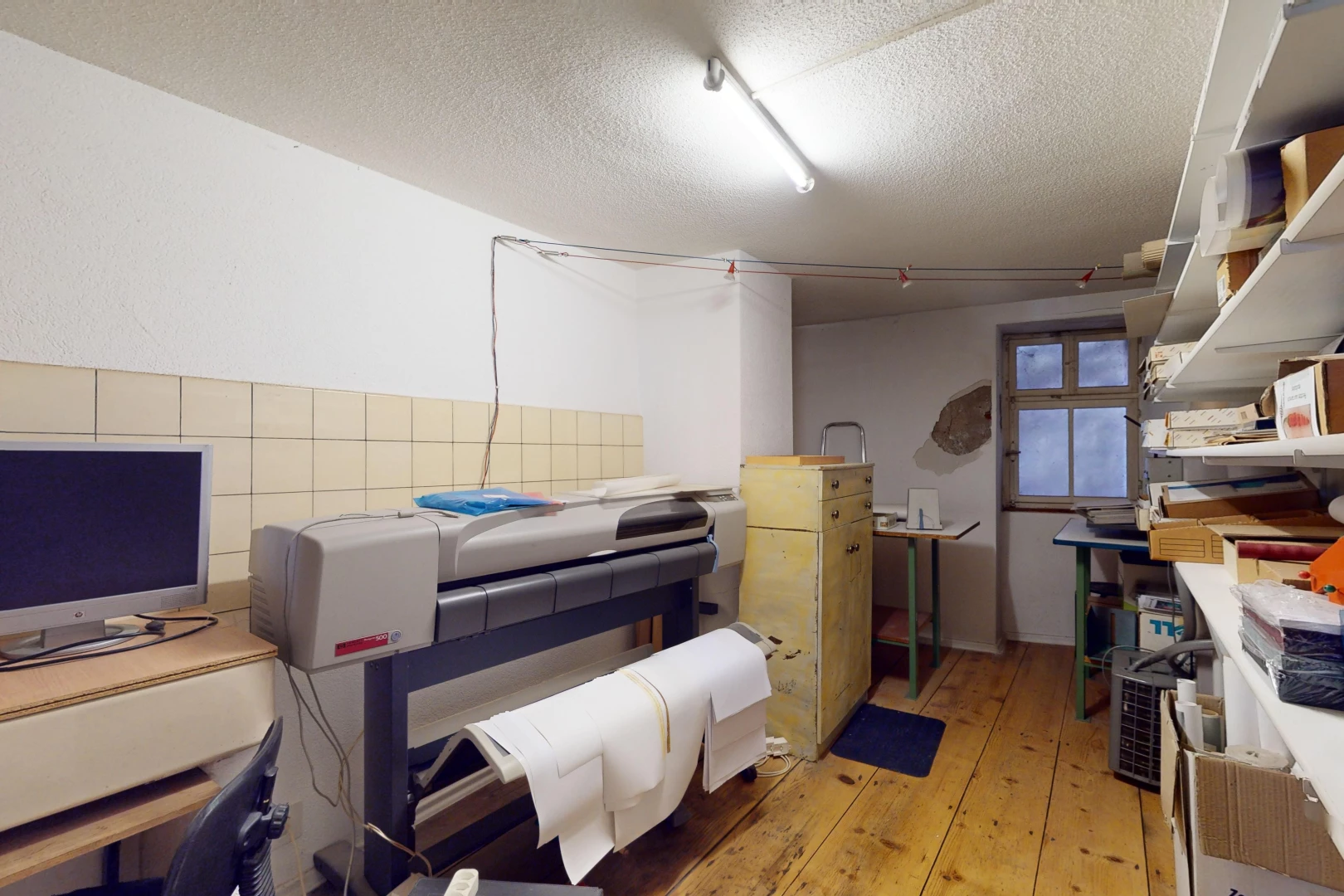 chambre avec télévision, plafond en crépis, lumière naturelle, et plancher de bois