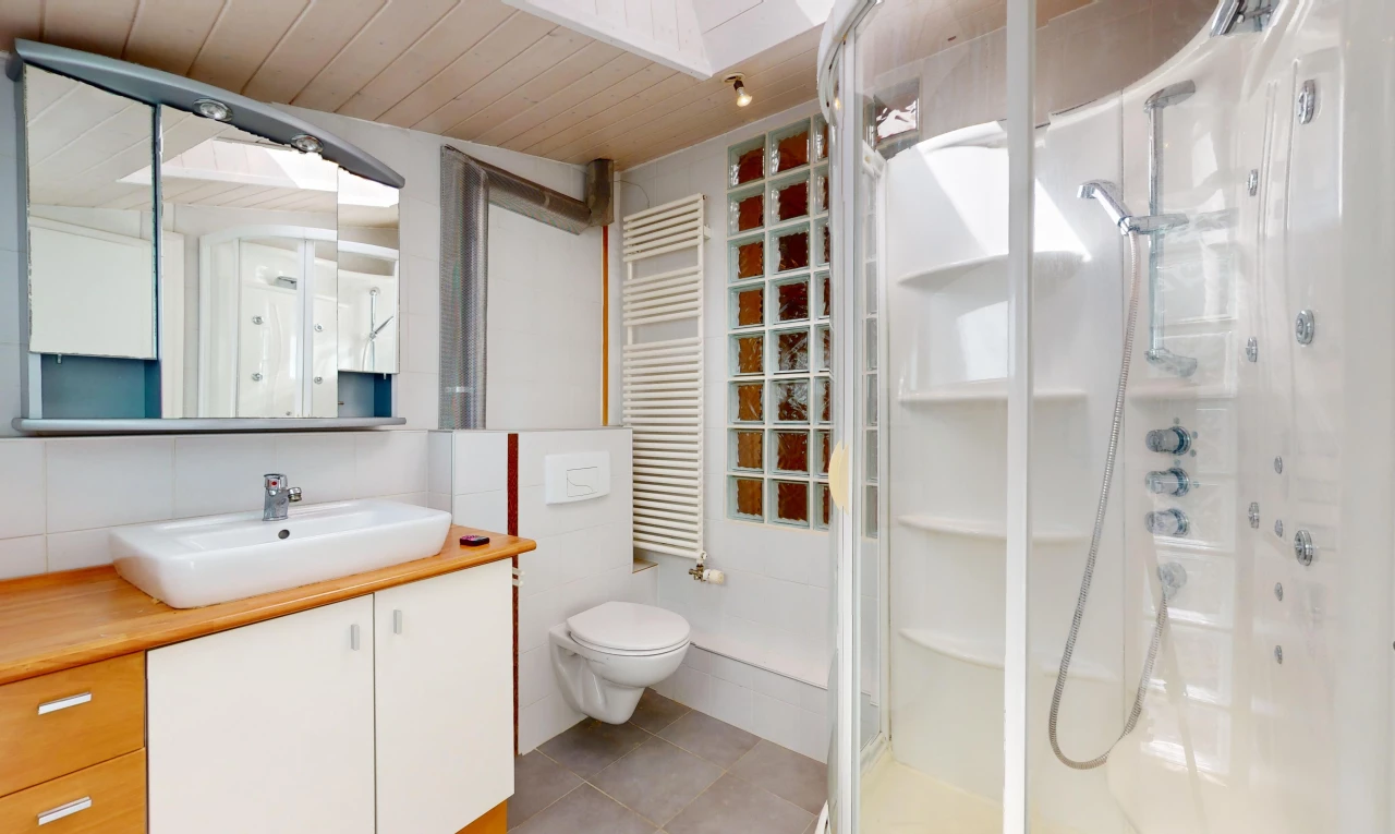 salle de bain avec plafond de bois, meuble-lavabo, miroir, toilettes, et radiateur
