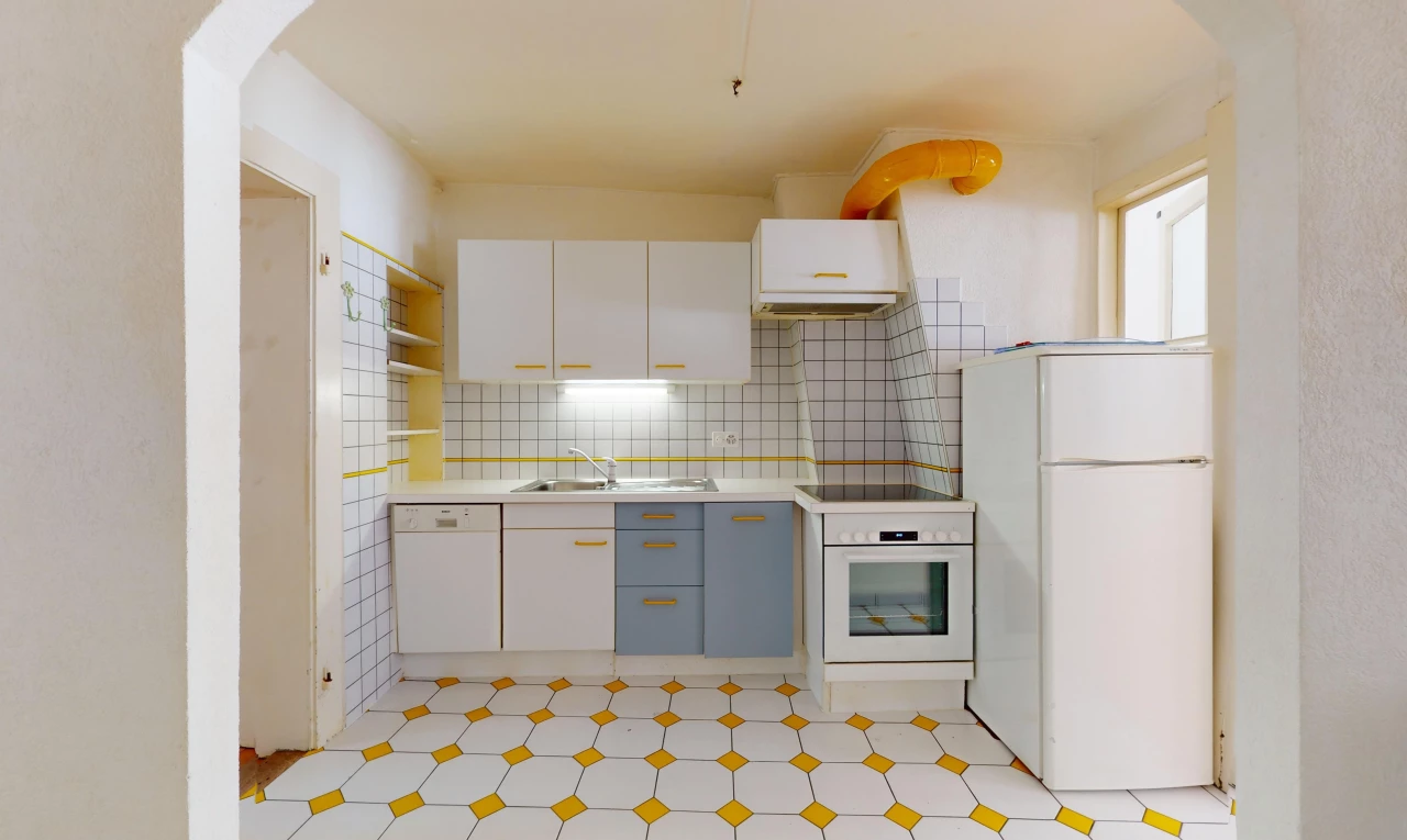 cuisine avec carrelage, réfrigérateur, four, et lave-vaisselle