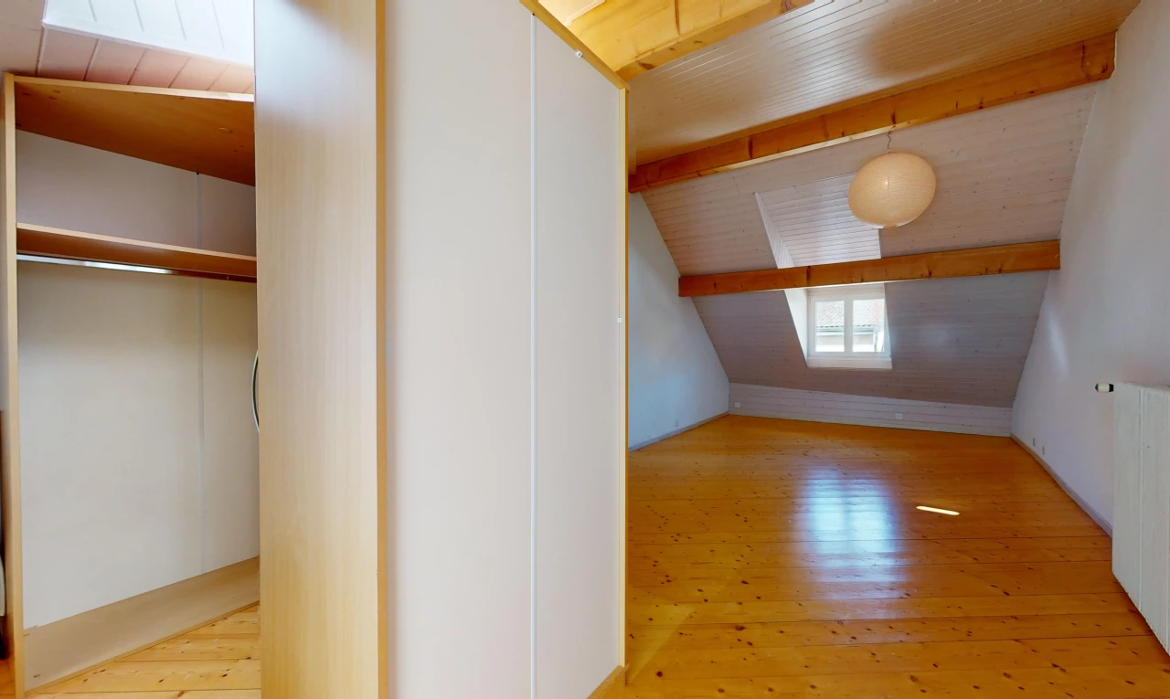 pièce vide avec plafond de bois, plancher de bois, lumière naturelle, poutres apparentes, et plafond voûté