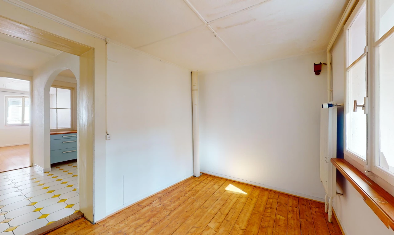 pièce vide avec plancher de bois, carrelage, lumière naturelle, et passerelles voûtées