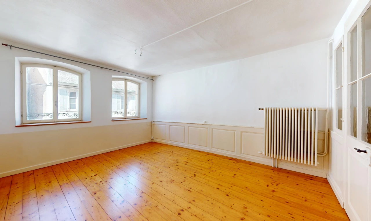 pièce vide avec plancher de bois, radiateur, et lumière naturelle