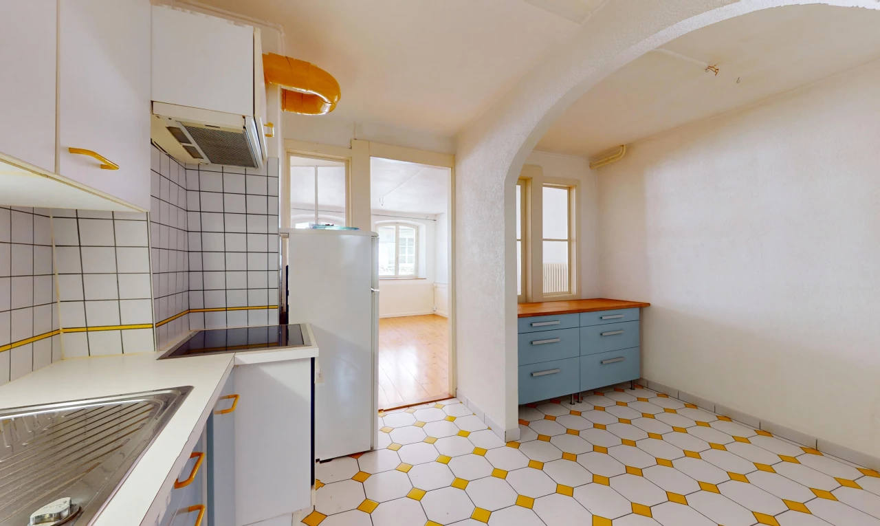 cuisine avec réfrigérateur, plancher de bois, carrelage, lumière naturelle, et hotte