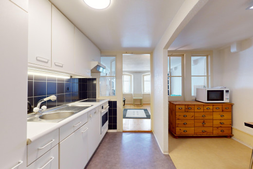 küche mit backsplash, weiße schränke, mikrowelle, natürliches licht, und arbeitsplatten