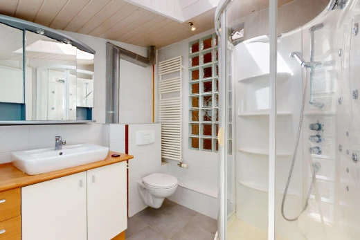 salle de bain avec plafond de bois, meuble-lavabo, miroir, toilettes, et radiateur