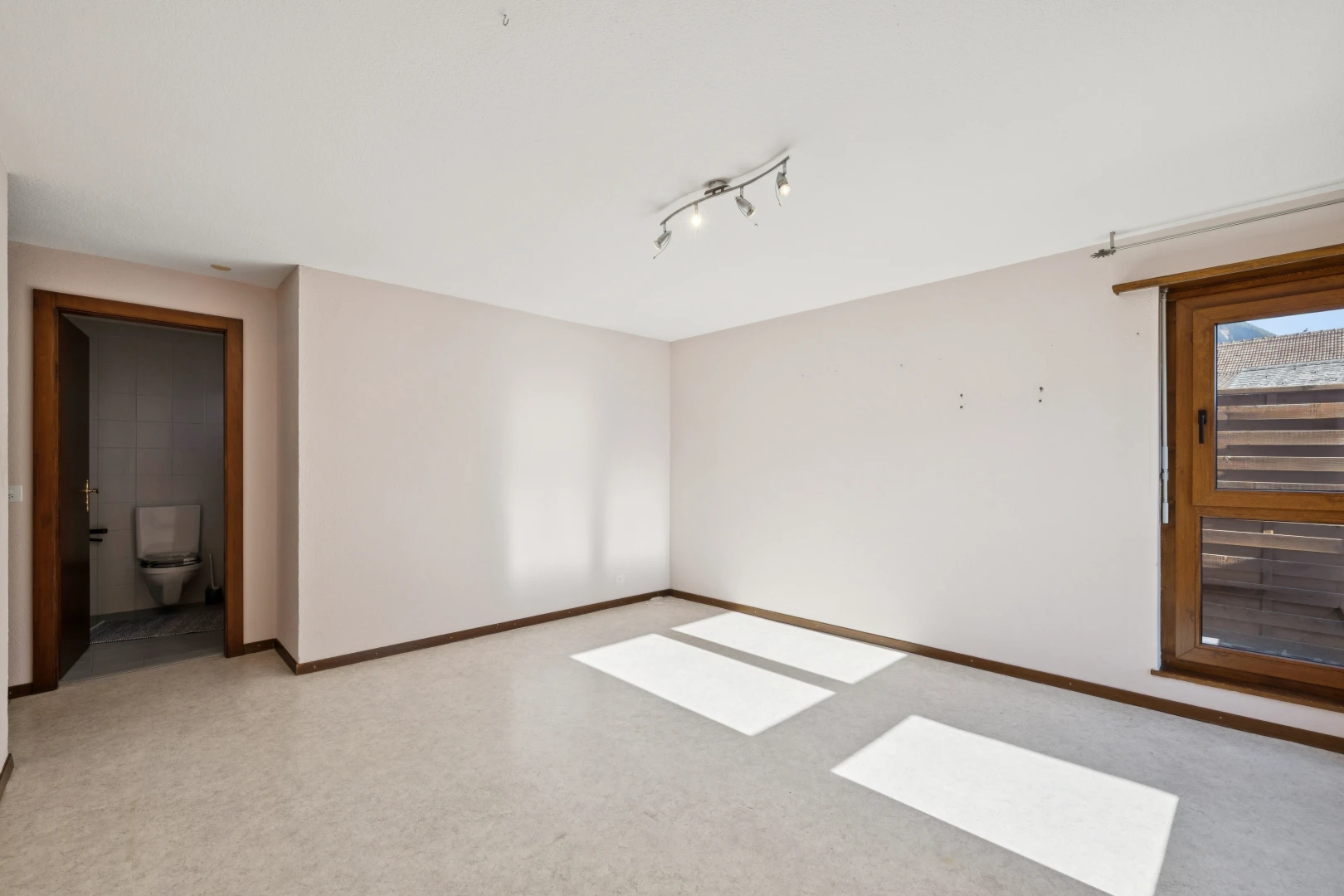 pièce vide avec cloison sèche, drywall, plinthes murales, baseboards wall, et éclairage sur rail