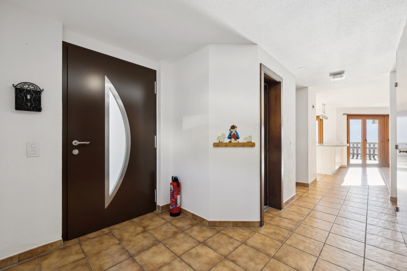 couloir avec accès à l'extérieur, cloison sèche, drywall, inside property, et light floor