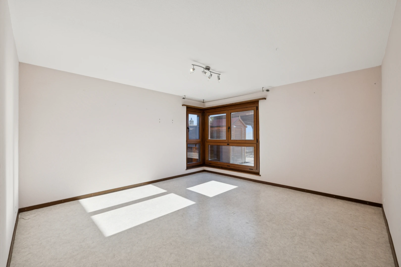 pièce vide avec éclairage sur rail, cloison sèche, drywall, plinthes murales, et baseboards wall