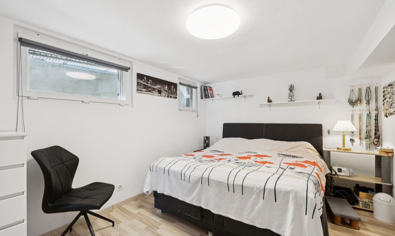 zimmer / schlafzimmer mit keller, gipskartonwand, drywall, holzfußboden, und wood finish floor