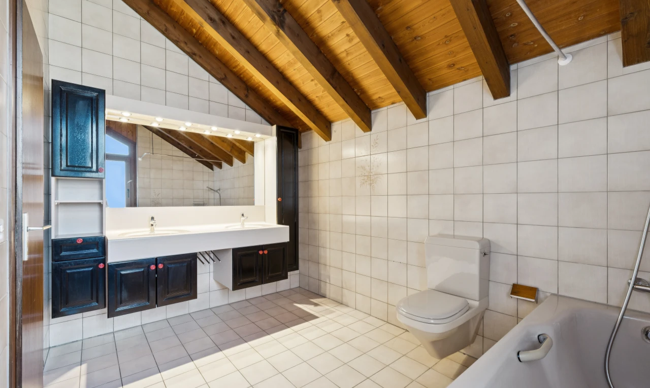 salle de bains avec mur en carrelage, tile wall, salle de bain complète, plafond à poutres, et beamed ceiling