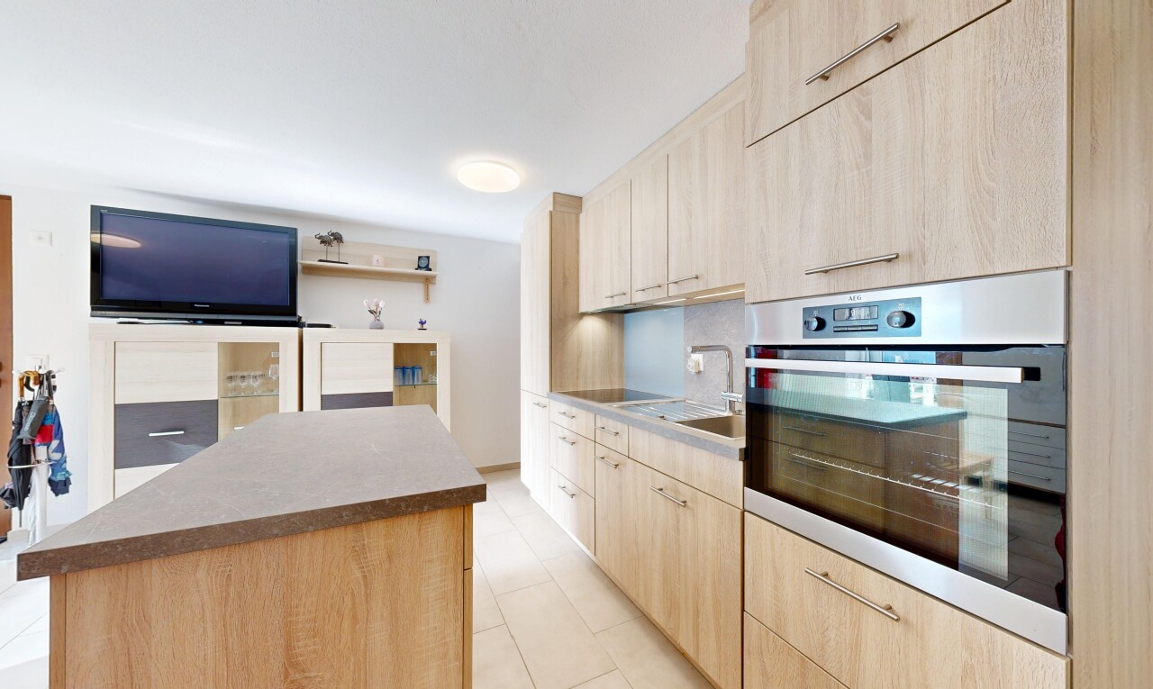 küche mit ofen, light brown cabinets, hellbraune schränke, fernseher, und light floor