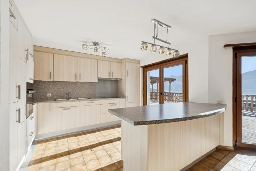 cuisine avec accès à l'extérieur, light floor, cloison sèche, drywall, et armoires marron clair
