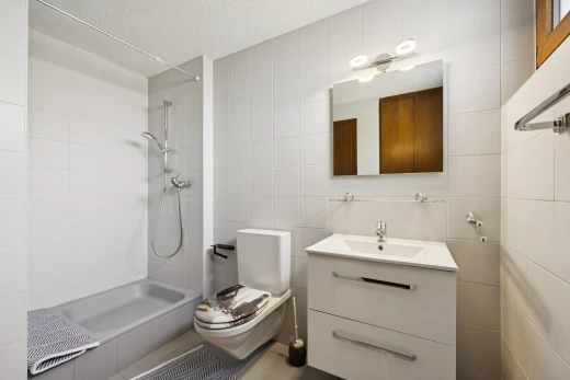 salle de bains avec mur en carrelage, tile wall, lavabo (ou coiffeuse selon le contexte), salle de bain complète, et miroir