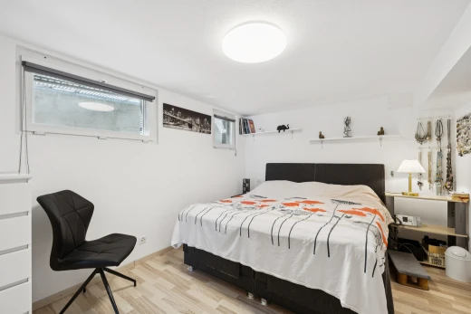 chambre avec sous-sol, cloison sèche, drywall, sol en finition bois, et wood finish floor