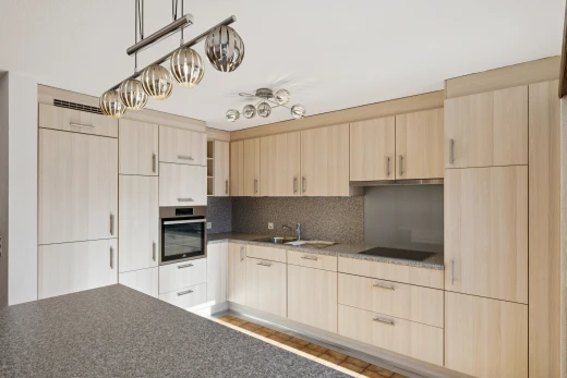 cuisine avec armoires marron clair, light brown cabinets, four, dark countertops, et inside property