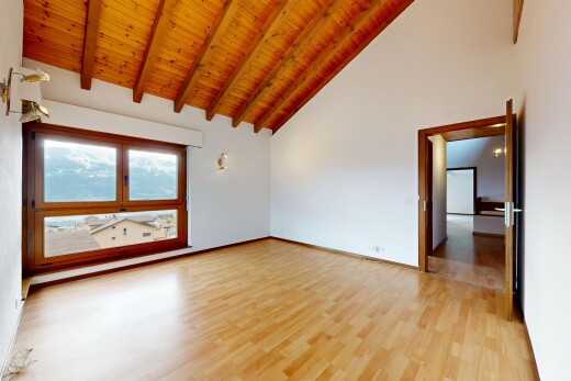 unfurnished room with light wood finished floors and a high wooden beamed ceiling