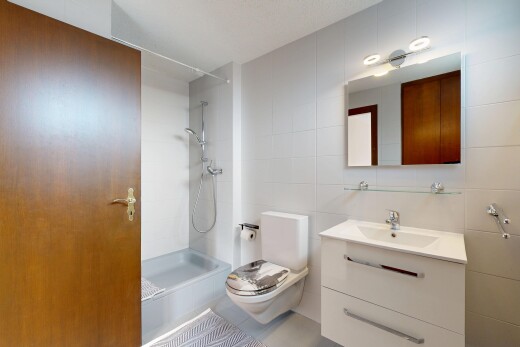 bathroom featuring vanity, walk in shower, and tile walls