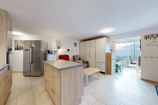 kitchen with light wood finish cabinets, stainless steel appliances, a center island, light countertops, and light tile patterned floors