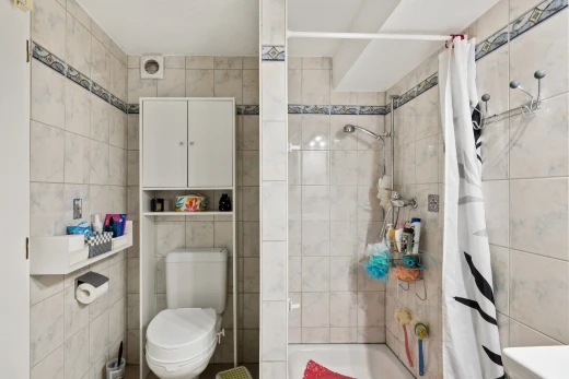 salle de bains avec toilette, salle de bain complète, douche-bain combinés, mur en carrelage, et tile wall