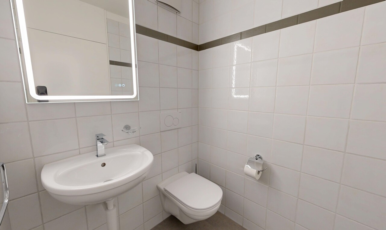 salle de bains avec mur en carrelage, tile wall, toilette, miroir, et inside property