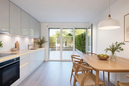 cuisine avec four, light countertops, flat panel cabinets, armoires à panneau plat, et éclairage suspendu