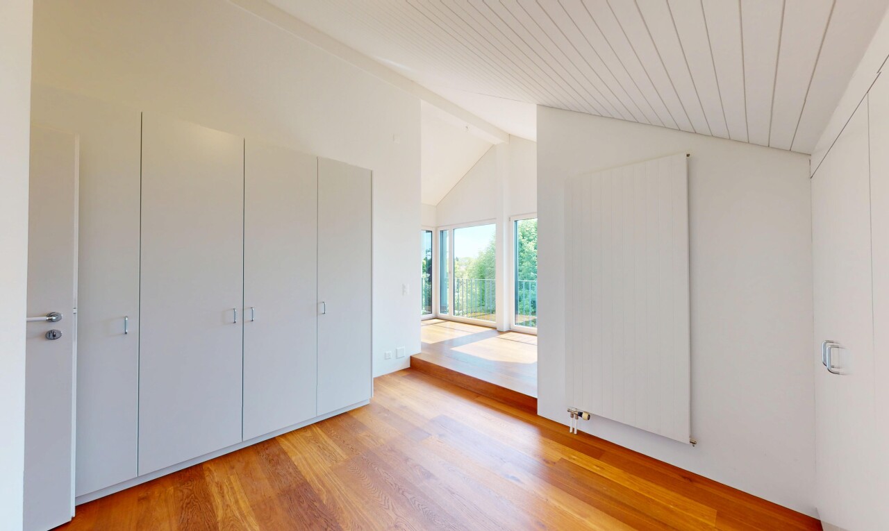 pièce vide avec wood finish floor, sol en finition bois, natural light, lumière naturelle, et vaulted ceiling