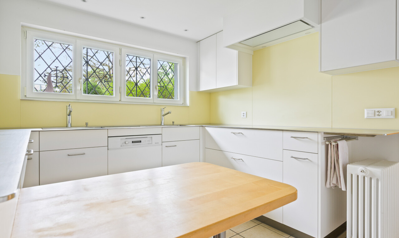 küche mit weiße schränke, kühler, arbeitsplatten, natural light, und tile floor