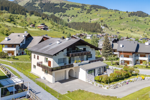 view of home with a balcony, an attached garage, driveway, and stucco siding