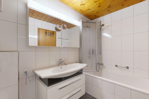 bathroom with tile walls, vanity, tiled shower / bath, wooden ceiling, and tasteful backsplash