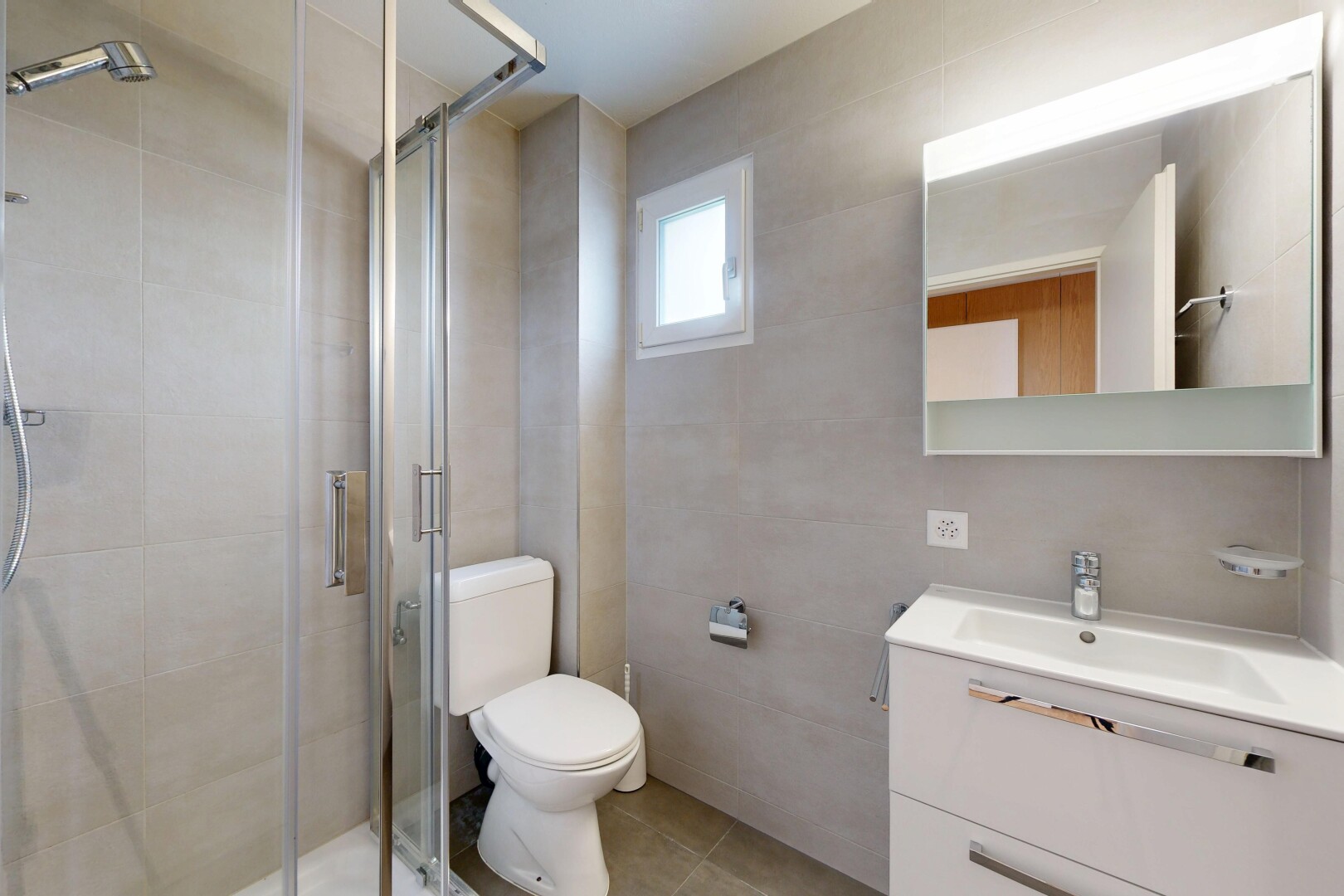 salle de bains avec miroir, salle de bain complète, douche, lavabo (ou coiffeuse selon le contexte), et toilette