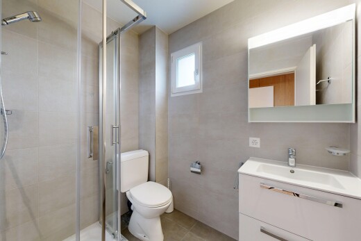 salle de bains avec miroir, salle de bain complète, douche, lavabo (ou coiffeuse selon le contexte), et toilette